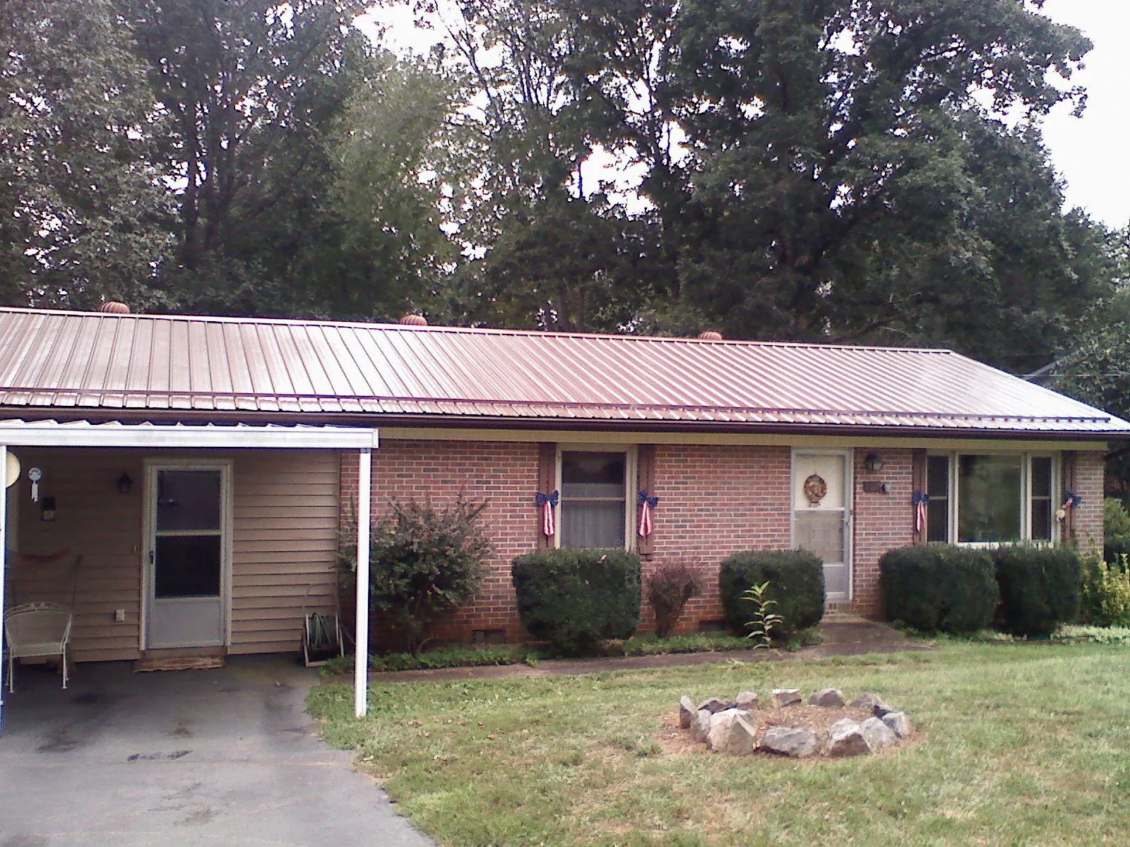 Bronze metal roof and carport on a brick ranch home — Roof Repair work by our crew in Miami