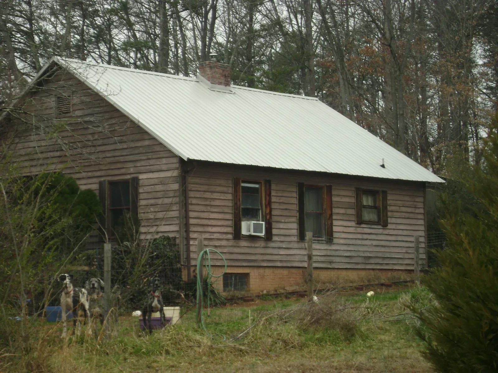 White metal roof on an old wood sided farmhouse, from a Metal Roof Installation job in Miami